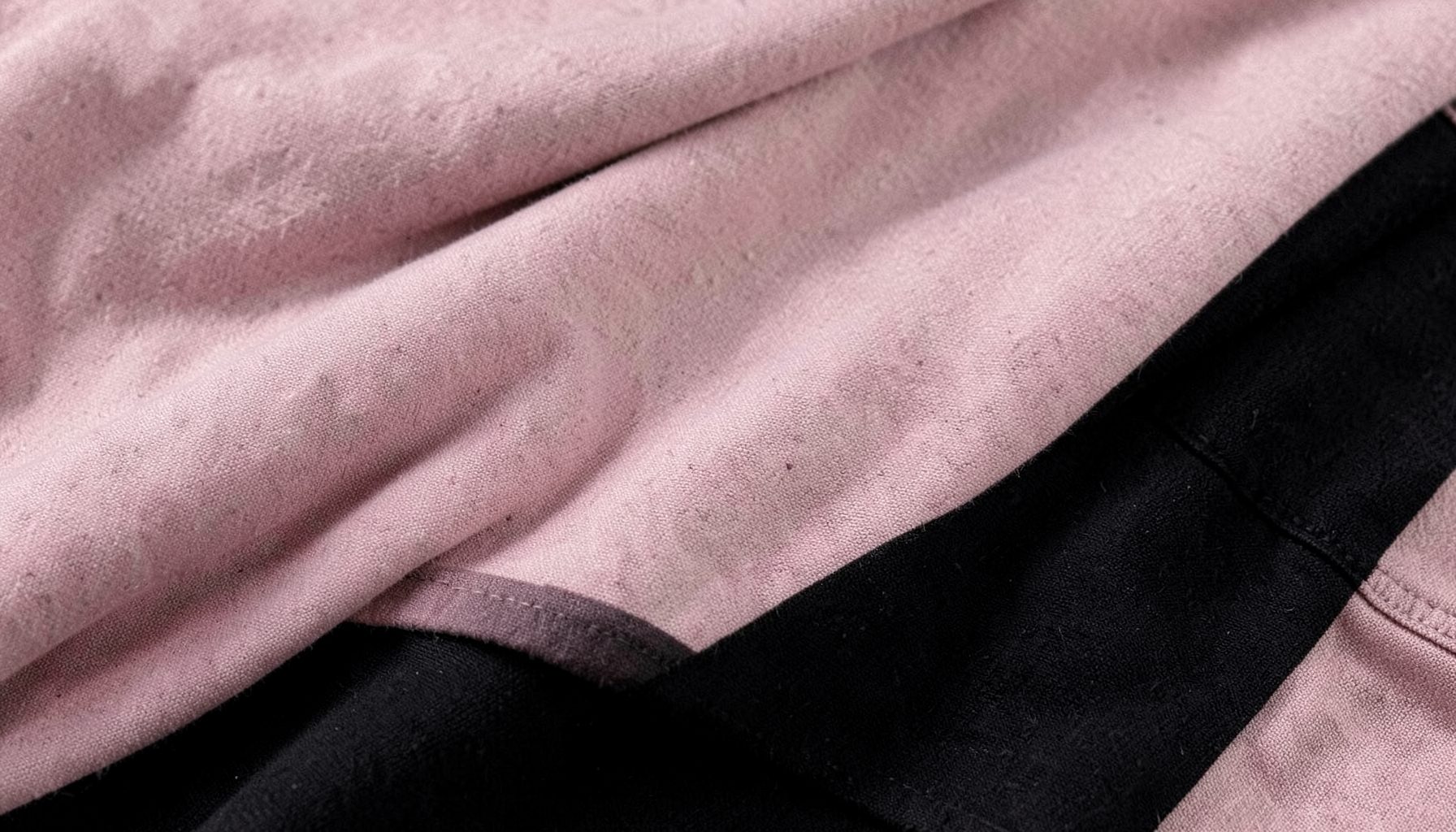 Muted pink and black fabric textures layered softly, casual fashion atmosphere